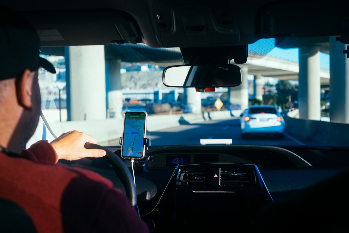Driver using a rideshare app on a phone in the car