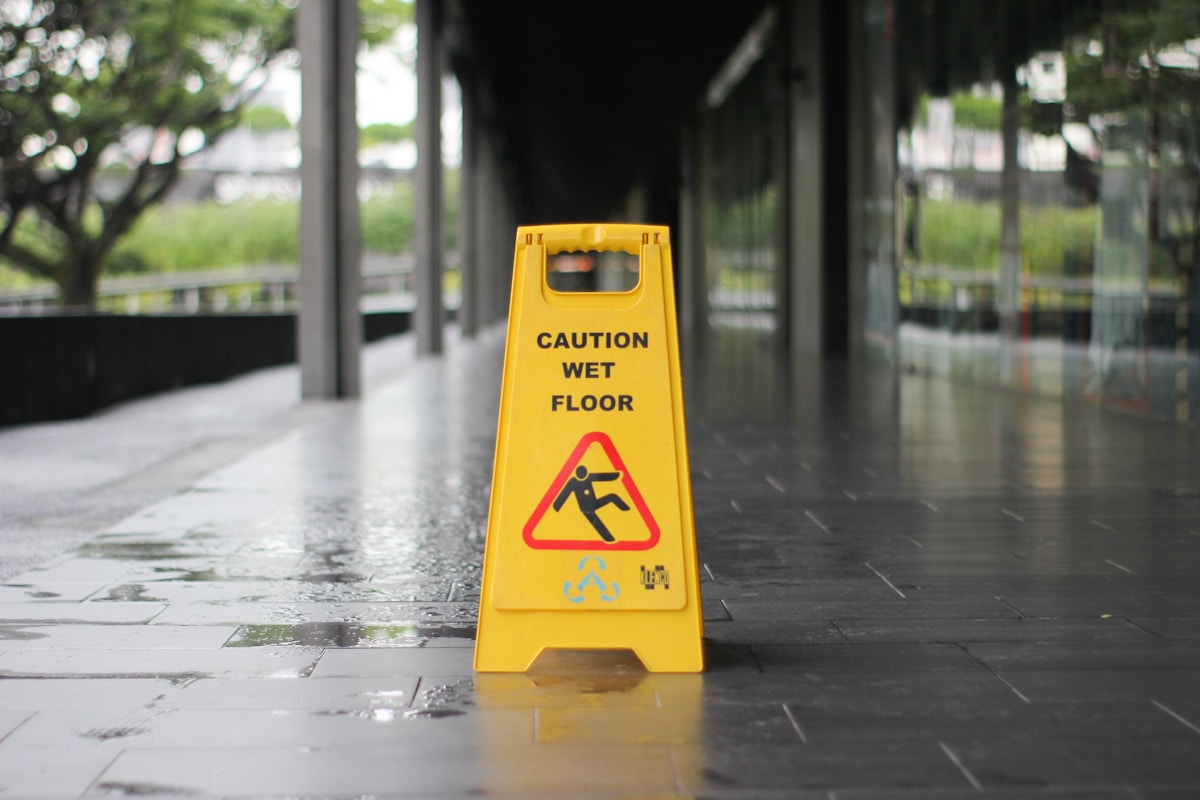 Yellow Caution Wet Floor sign on a wet walkway